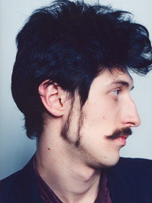 Hutz with black hair and double sideburns.